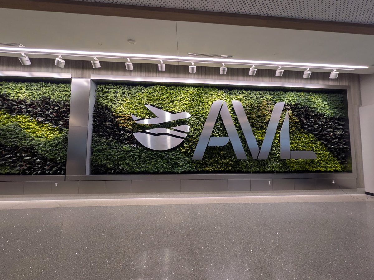 The living plant wall in baggage claim at Asheville Regional Airport with the AVL logo mounted across the greenery