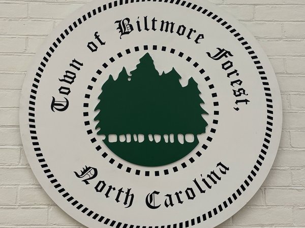 The round Town of Biltmore Forest, North Carolina seal mounted on the white brick chimney
