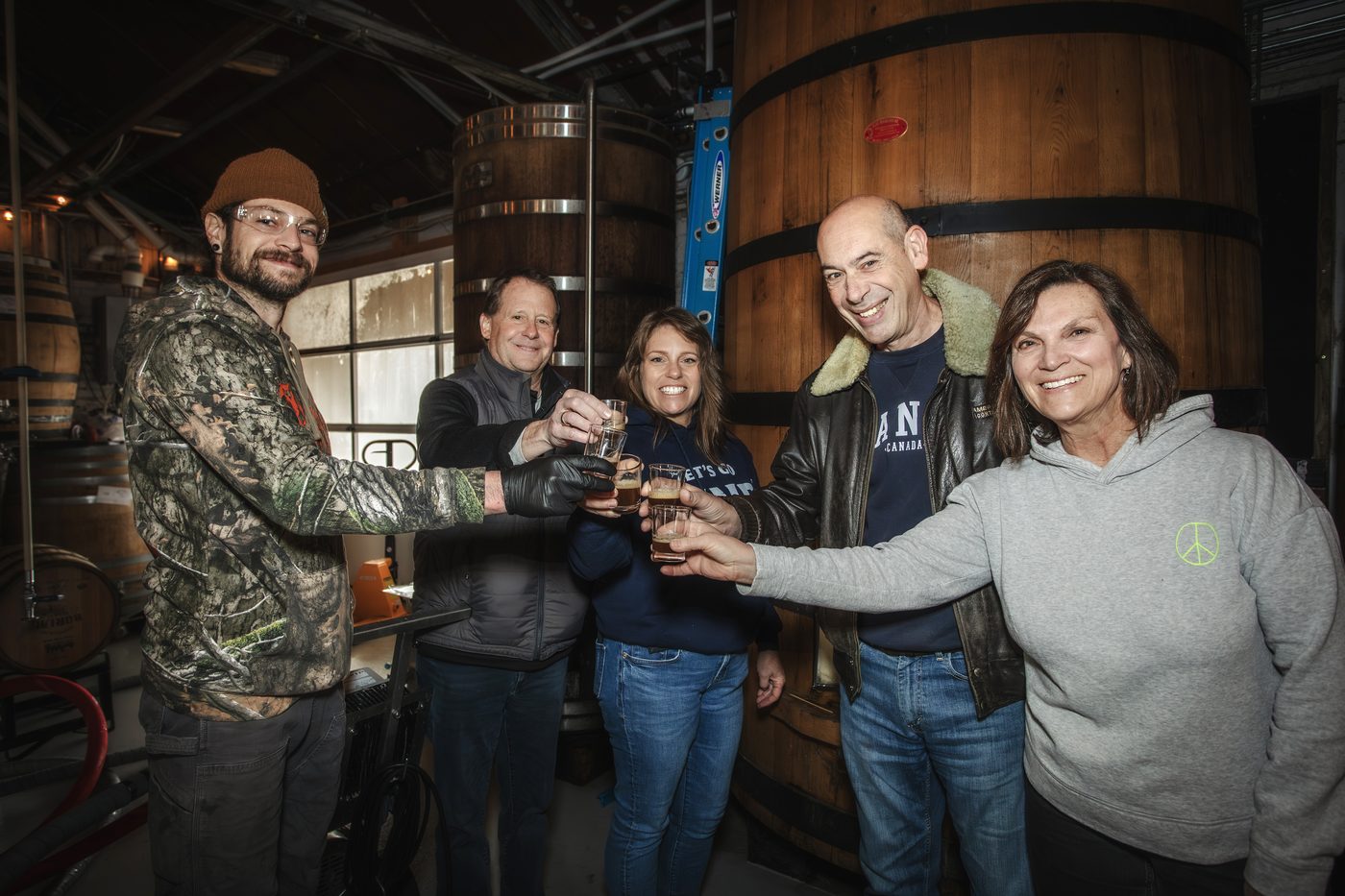 Tim Gormley with members of the Echoes of the Forest team raising tasting glasses of the brown ale at Burial Beer Co.'s Forestry Camp