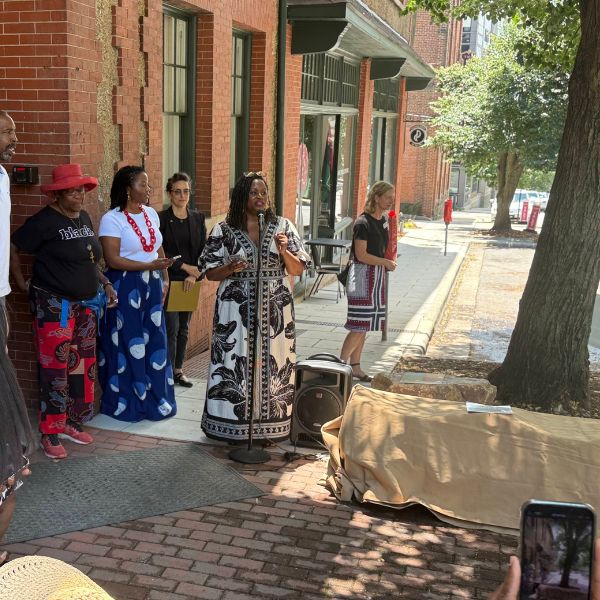 Speakers address the crowd at the corner of Eagle and Market Streets before the unveiling