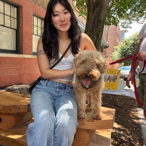 A visitor and her dog share a seat on the bench