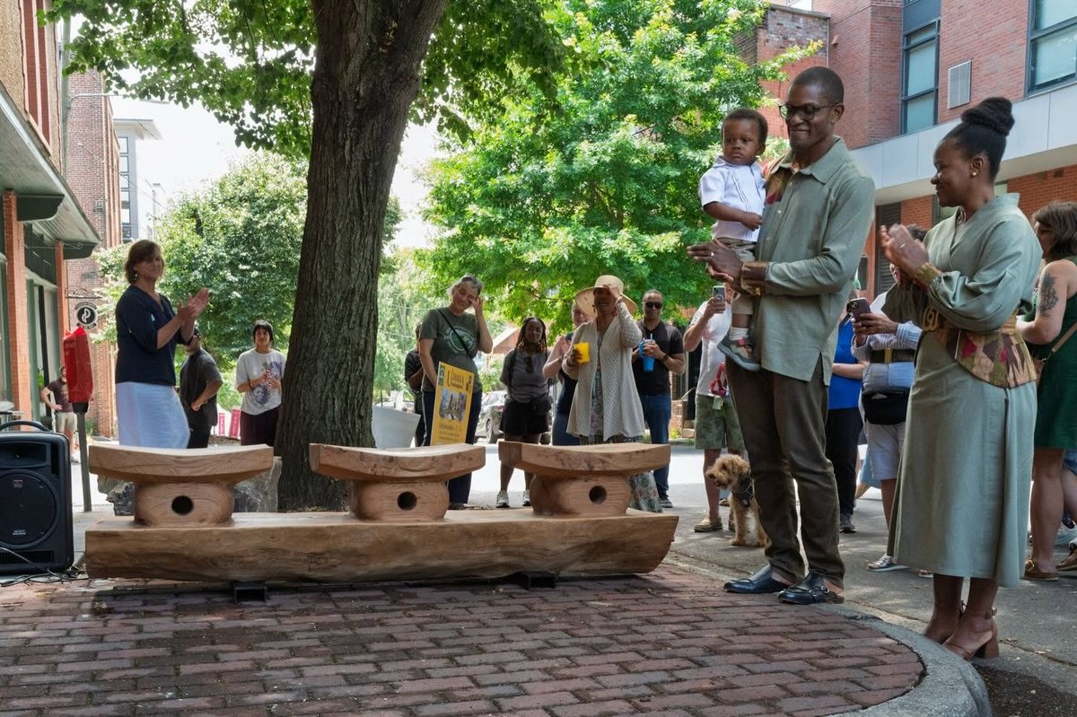 The newly unveiled white oak bench at the YMI Cultural Center as the crowd applauds on Juneteenth