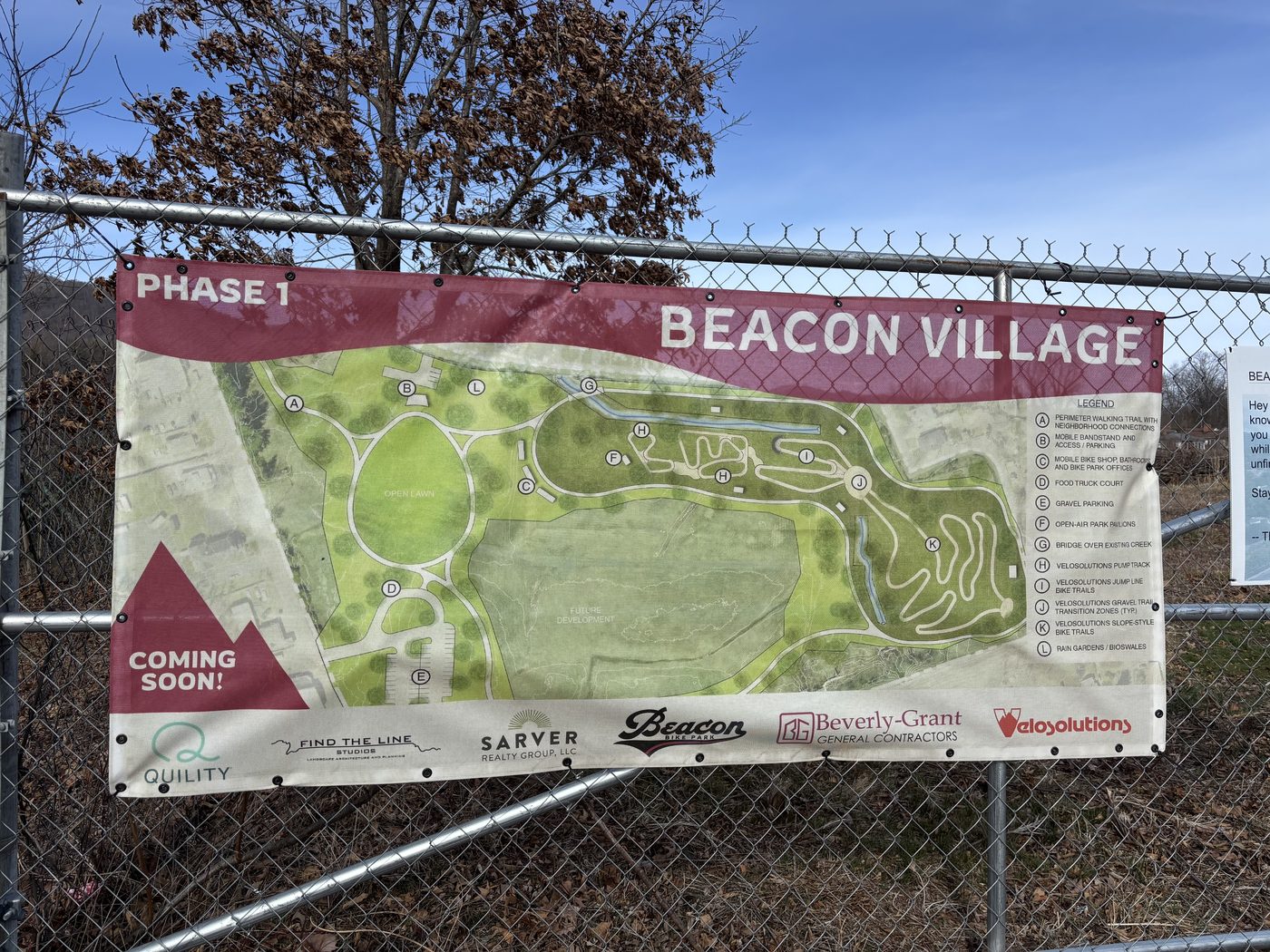 Beacon Village Phase 1 site banner showing the new community park layout, with a 'Coming Soon' announcement on the construction fence
