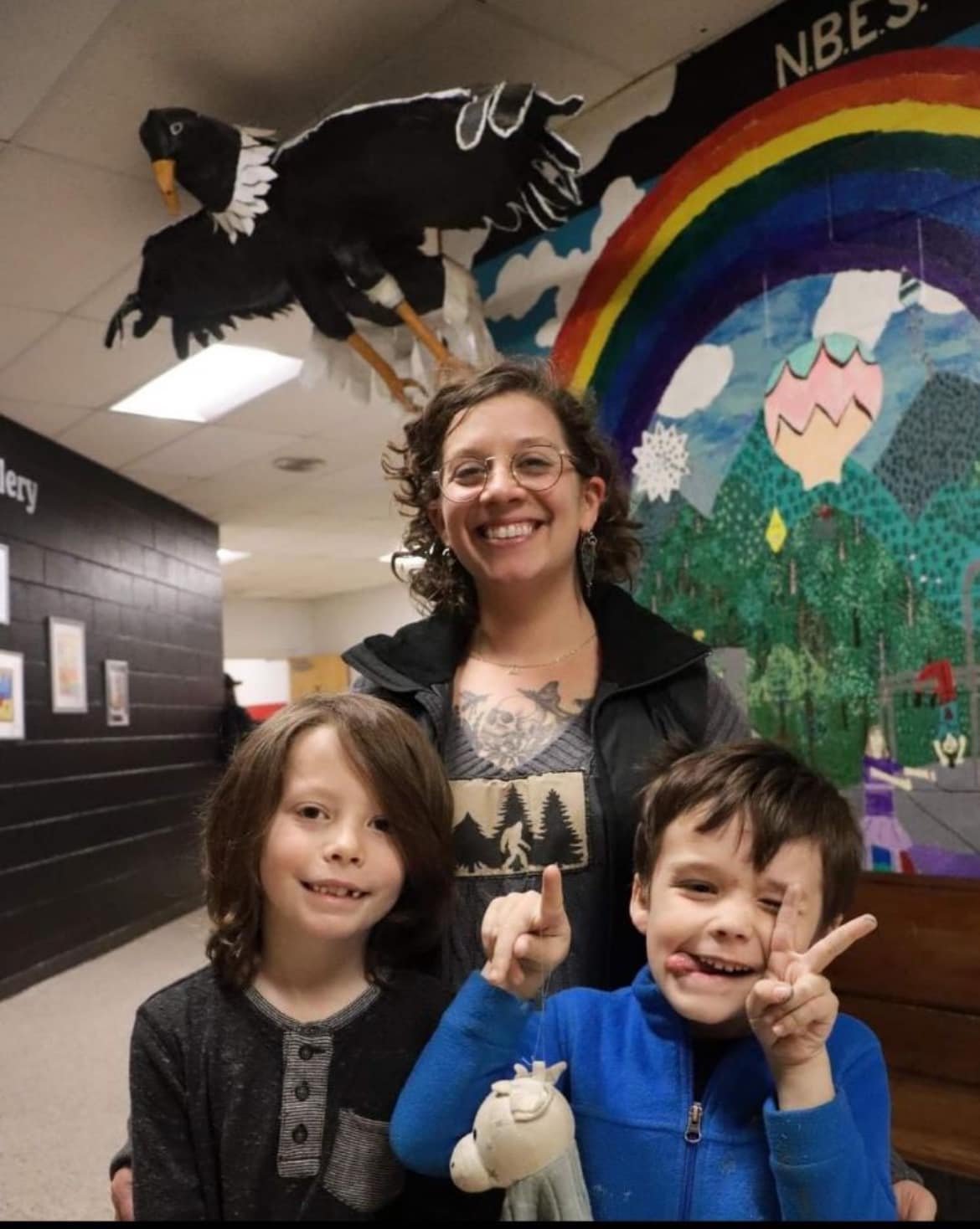 Alison Wisely with her sons Felix and Lucas at North Buncombe Elementary School, photographed in front of student artwork in the school hallway