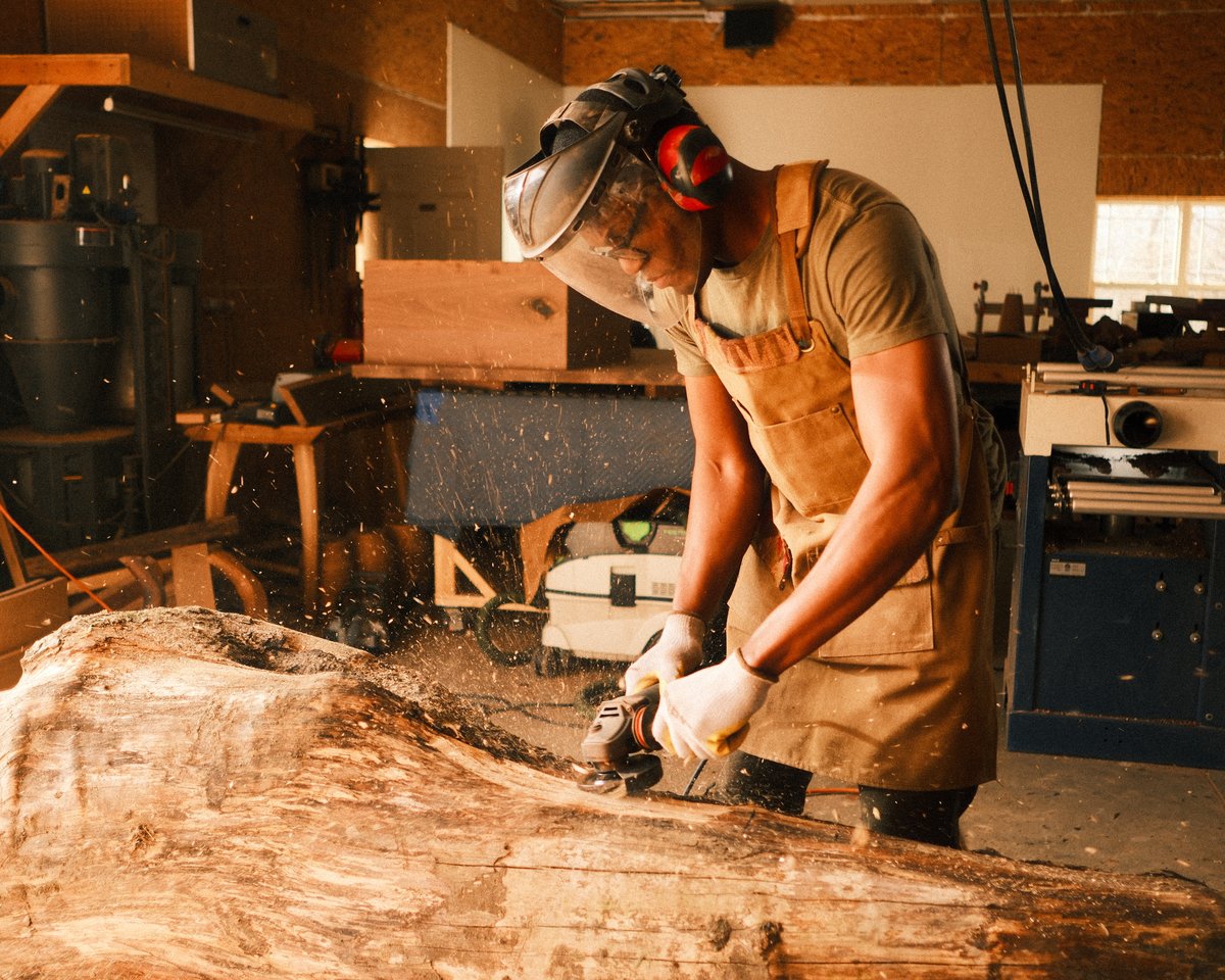 Artisan shaping salvaged timber in the workshop